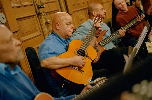 Men play guitar.
