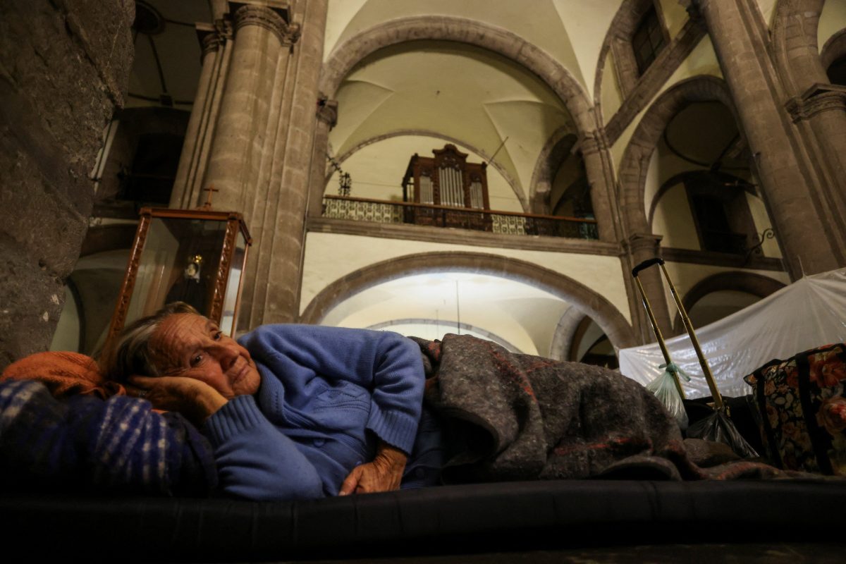 Una anciana migrante de Venezuela descansa mientras pasa la noche en la Iglesia de Nuestra Señora de la Soledad en Ciudad de México el 27 de noviembre de 2023, mientras ella y otros migrantes esperan una cita con la Oficina de Aduanas y Protección Fronteriza de Estados Unidos a través de la aplicación para teléfonos inteligentes CBP One de la agencia.