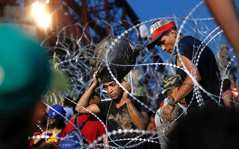 Solicitantes de asilo esperan a orillas del Río Grande en Piedras Negras, México, el 26 de septiembre de 2023, después de cruzar durante su viaje a través de México a Eagle Pass, Texas. El presidente de EE.UU., Joe Biden, firmó el 4 de junio una orden ejecutiva que suspende temporalmente las solicitudes de asilo.
