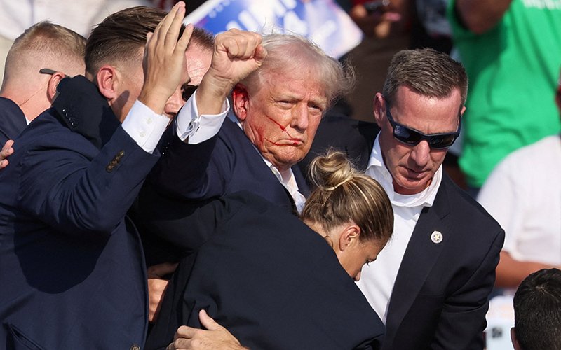 Republican presidential candidate and former U.S. President Donald Trump is assisted by security personnel after gunfire rang out during a campaign rally at the Butler Farm Show in Butler, Pa., July 13, 2024. A local prosecutor says the suspected gunman and at least one attendee are dead.